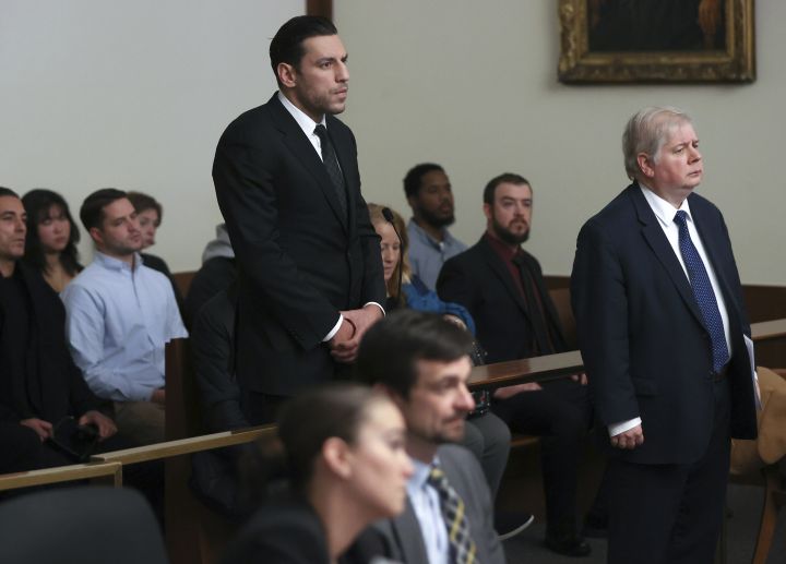 Boston Bruins forward Milan Lucic, centre, stands during his arraignment Tuesday, Nov. 21, 2023, in Boston Municipal Court in Boston, on an assault charge in connection with his arrest over the weekend after his wife called police to their home and said he tried to choke her. Lucic has been released on personal recognizance bail after pleading not guilty to assaulting his wife.