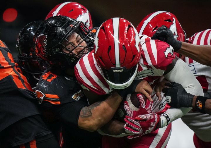 B.C. Lions' Sione Teuhema, left, tackles Calgary Stampeders' Ka'Deem Carey during the first half of a CFL football game, in Vancouver, on Friday, October 20, 2023. The CFL suspended Teuhema for one game Friday following an incident in last week's 41-16 loss to the Calgary Stampeders.