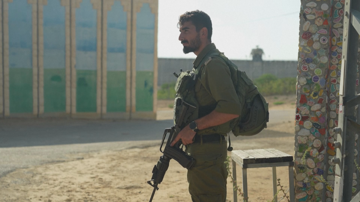 An Israeli soldier stands next to a painted door