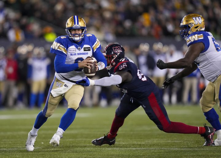 Winnipeg Blue Bombers quarterback Zach Collaros (8) looks to throw as he evades a tackle from Montreal Alouettes defensive lineman Lwal Uguak (96) during the first half of football action at the 110th CFL Grey Cup in Hamilton, Ont., on Sunday, November 19, 2023.