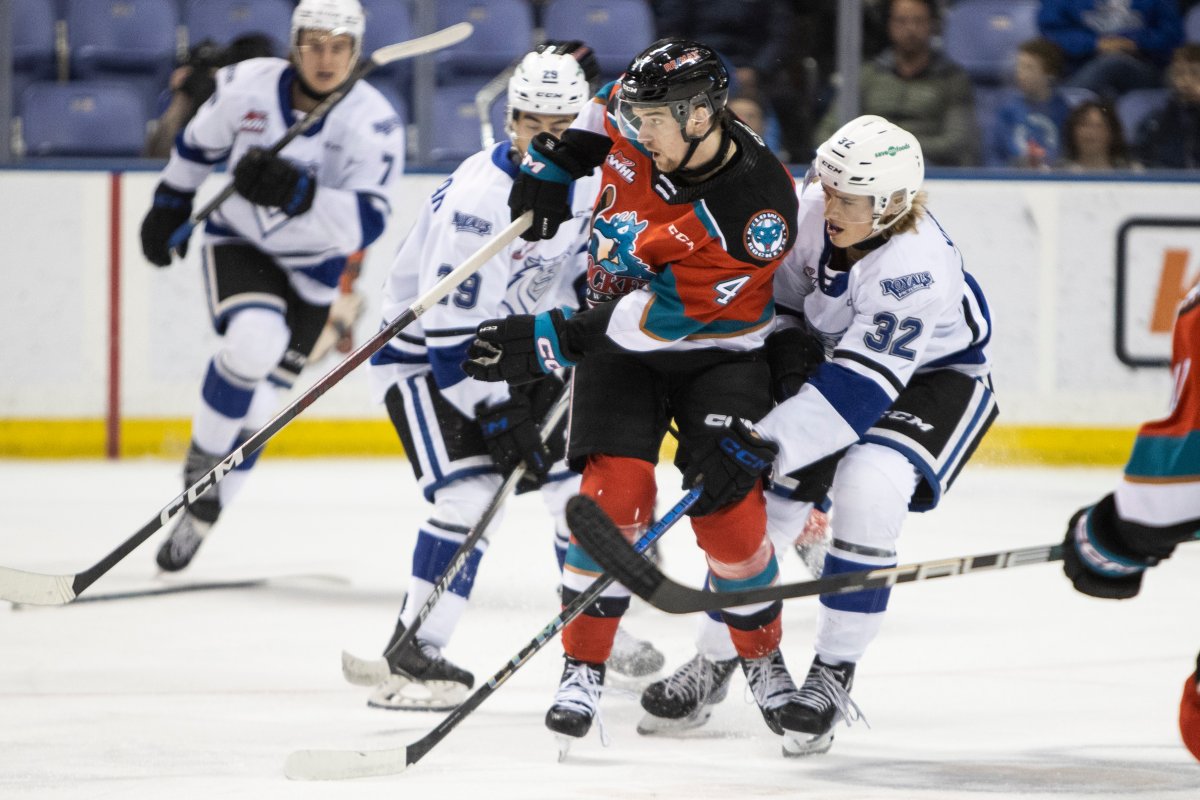 Caden Price of the Kelowna Rockets is defensively hounded by Deegan Kinniburgh of the Victoria Royals during WHL action in Victoria, B.C., on Monday night.