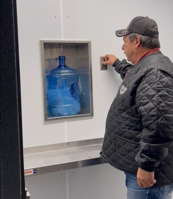Chief Barry McKay of Tootinaowaziibeeng Treaty Reserve, fills a water jug using a new water filtration pod.