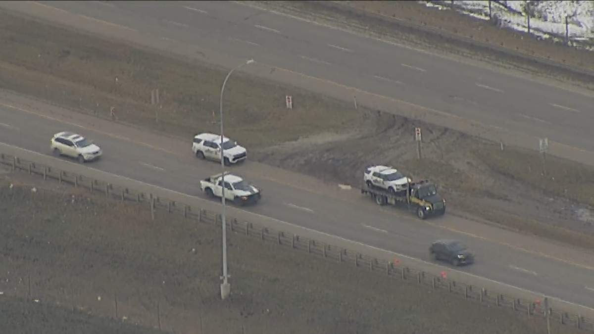 An RCMP vehicle is loaded onto a flatbed trailer after it was rammed while trying to pull over a reportedly-erratic driver on Highway 2 near Calgary on Nov. 2, 2023.