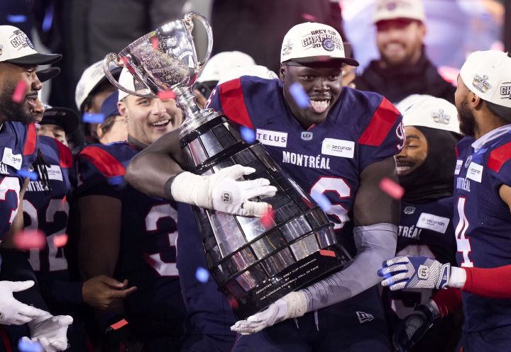 Montreal Alouettes defensive lineman Lwal Uguak (96) poses with the Grey Cup after the Alouettes defeated the Winnipeg Blue Bombers to win the 110th CFL Grey Cup in Hamilton, Ont., on Sunday, November 19, 2023.