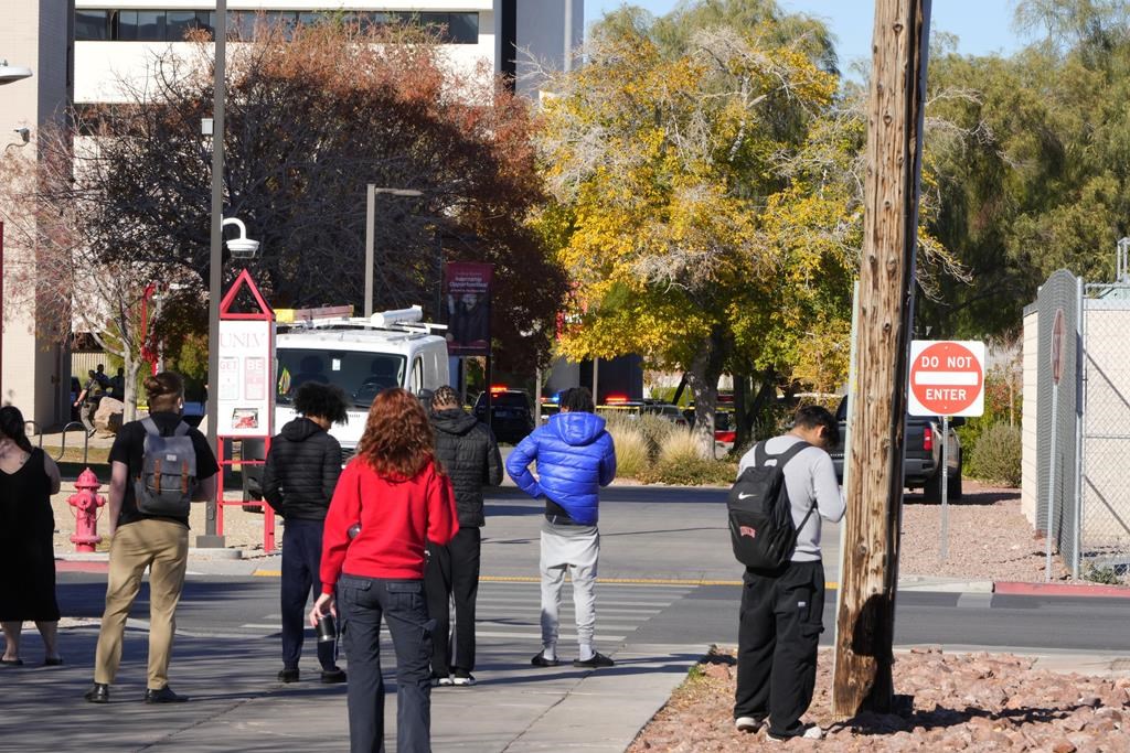 University of Nevada, Las Vegas, students observe police activity after a shooting reported on campus, Wednesday, Dec. 6, 2023, in Las Vegas. (AP Photo/Lucas Peltier)