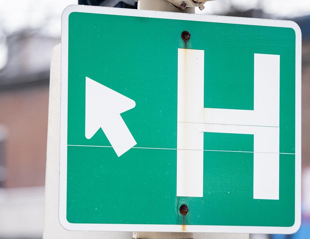 A closeup of a road sign for a hospital.