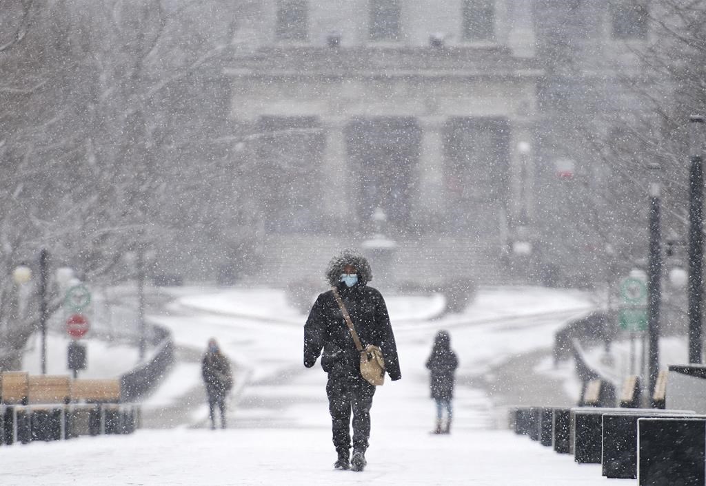 A person walks through the McGill University campus during light snowfall in Montreal on Sunday, Dec. 20, 2020. McGill University says it will offer a $3,000 annual award to new undergraduate students from other provinces to offset a tuition hike imposed by the provincial government. 