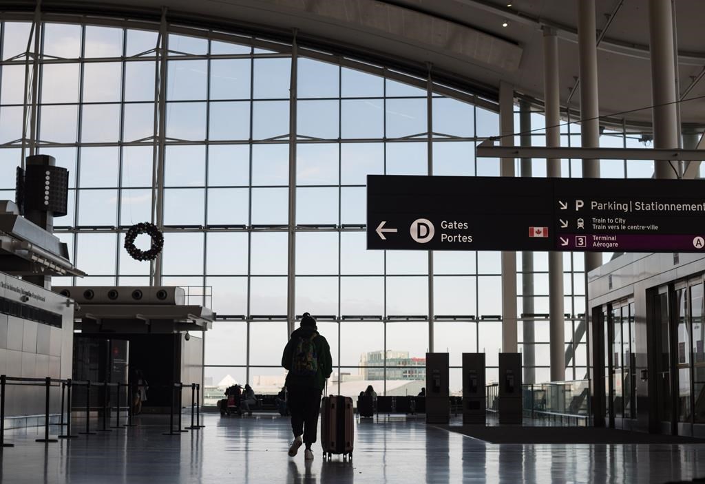 Travellers are photographed at Toronto Pearson International Airport on Thursday, Dec. 16, 2021.
