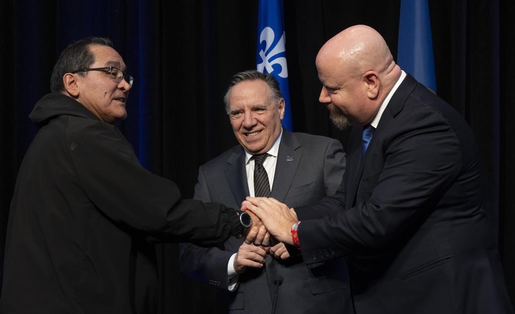 Quebec Premier François Legault, centre, looks on as Makivvik Corporation president Pita Aatami, left, shakes hands with Quebec Indigenous Affairs Minister Ian Lafrenière, after signing an agreement to resume negotiations for more Inuit autonomy in Montreal, Wednesday, Dec. 20, 2023.