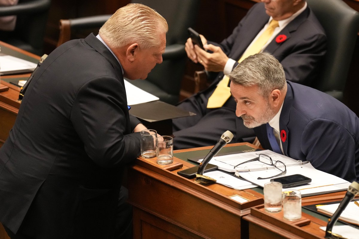Ontario Premier Doug Ford, left, confers with Minister of Municipal Affairs and Housing, Paul Calandra, at Queen's Park, in Toronto, Monday, Oct. 30, 2023. 