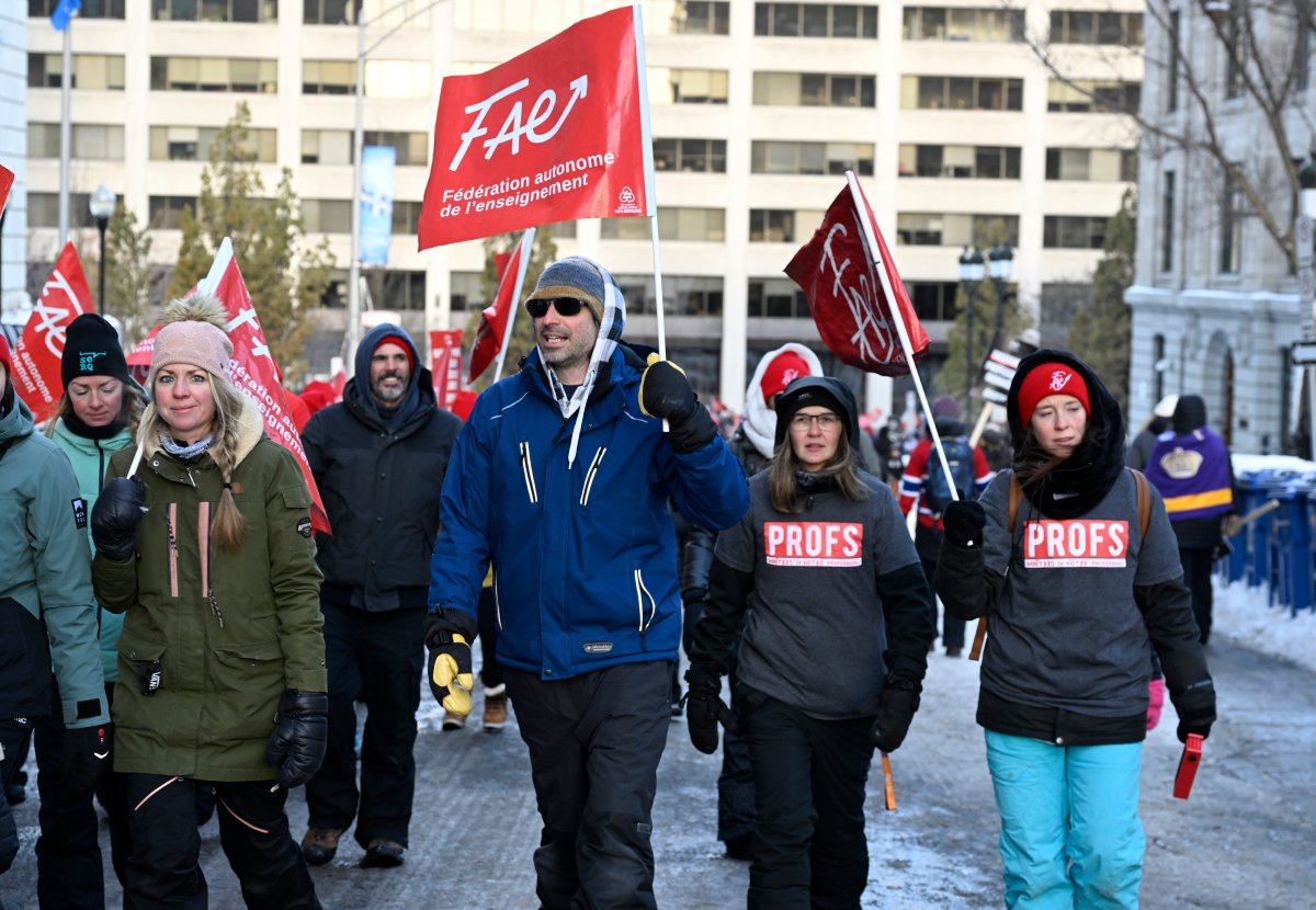 Teachers, members of the FAE union, walk by the National Assembly and the Education ministry, Wednesday, Nov. 29, 2023 at the legislature in Quebec City. 