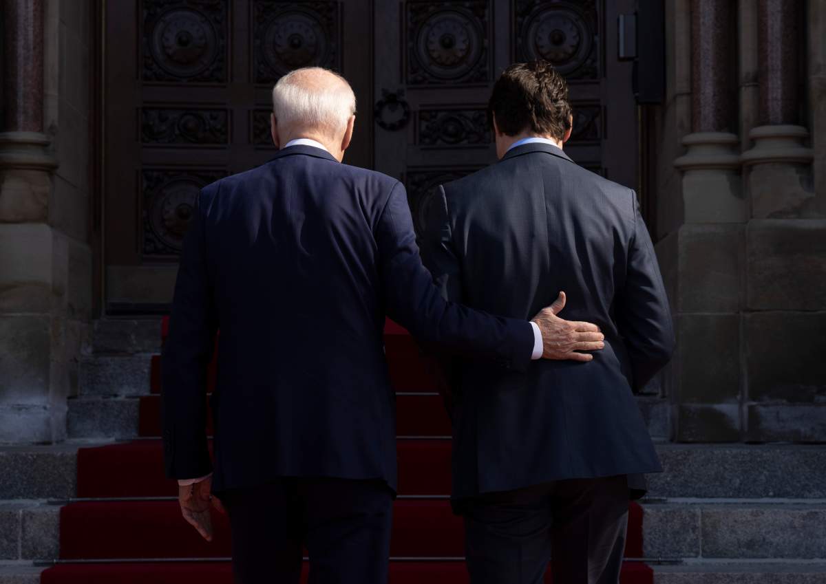 U.S. President Joe Biden places his hand on Prime Minister Justin Trudeau’s back as they enter the Parliament buildings, in Ottawa, Friday, March 24, 2023. THE CANADIAN PRESS/Adrian Wyld