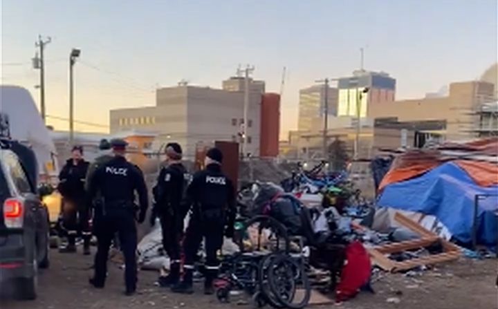 Edmonton police officers began dismantling a homeless encampment in the city's core on Friday morning.