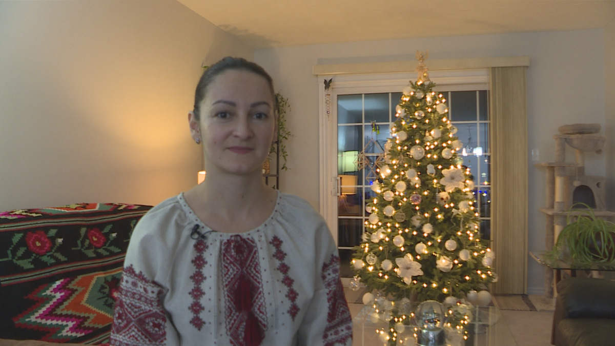 A woman in front of a Christmas tree.