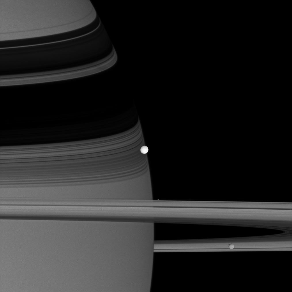 NASA’s Cassini spacecraft captured this image of reflective Enceladus, seen at centre, as it orbits Saturn. Also in the 2007 image are two other moons: Pandora, a bright speck hovering near the rings, and Mimas, at lower right.