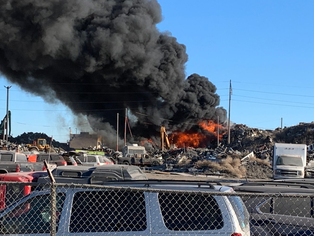 A scrap metal pile continues to burn as fire crews work together to extinguish the blaze north of the city.