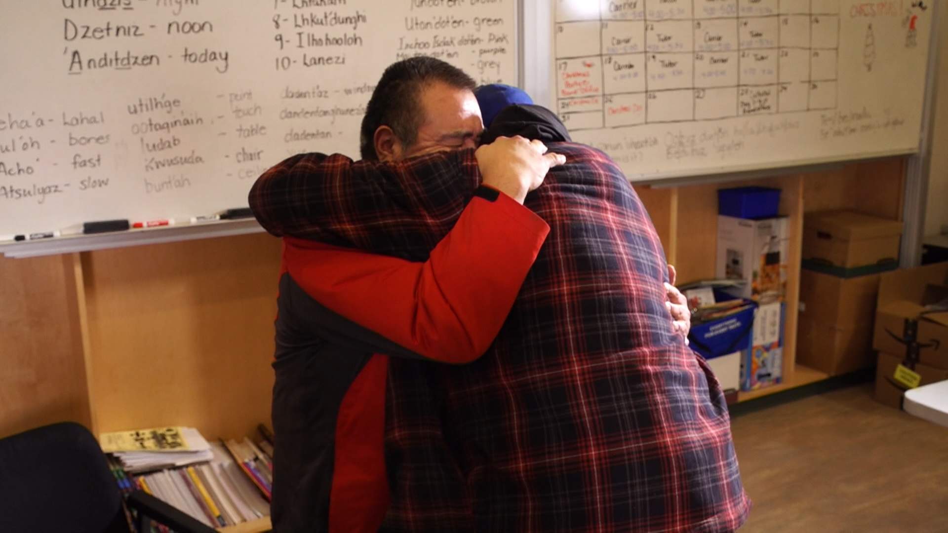 Two men embrace as they meet for the first time.