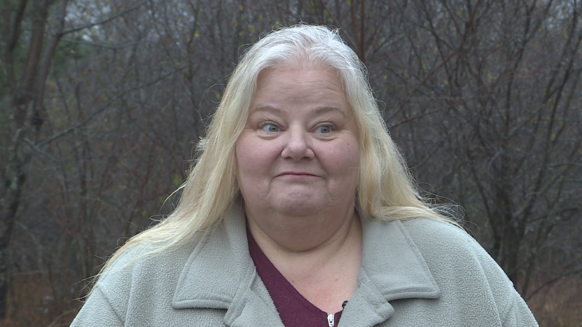 A woman with white hair and a beige sweater
