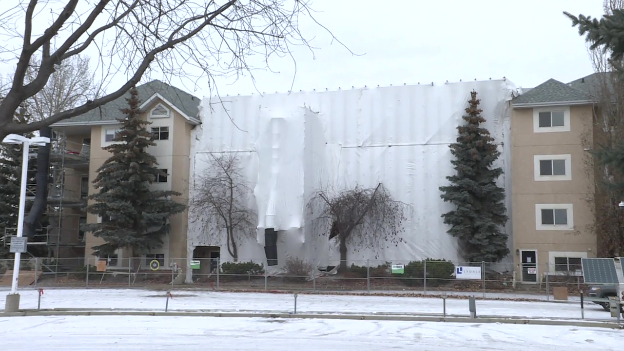 Скеле и строителна обвивка обграждат едно крило на сграда с