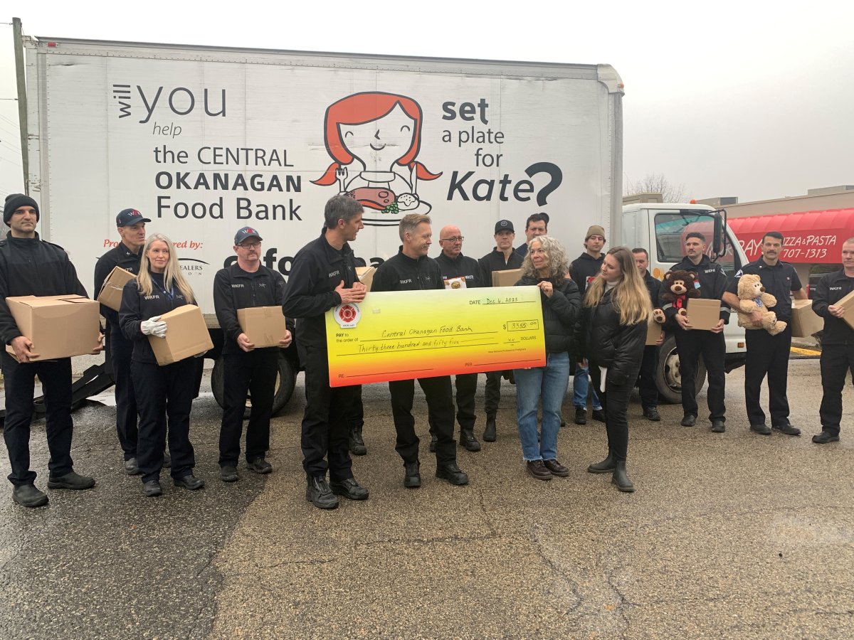 Holding boxes of donated food, West Kelowna firefighters and members of the Central Okanagan Food Bank gather for a cheque presentation on Wednesday.