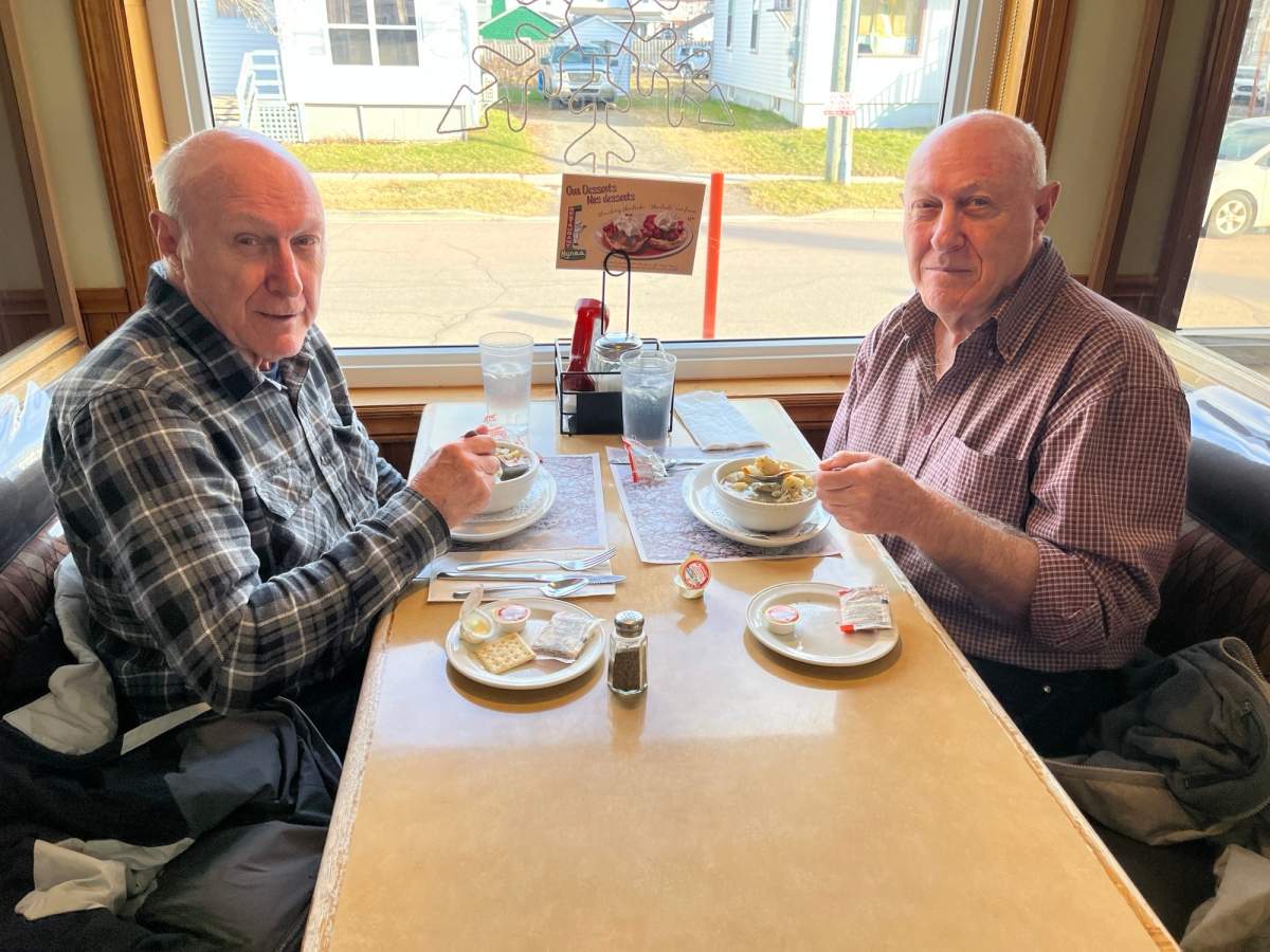 Twins Aldore and Dollard LeBlanc eat fricot, an Acadian chicken stew, at Hynes