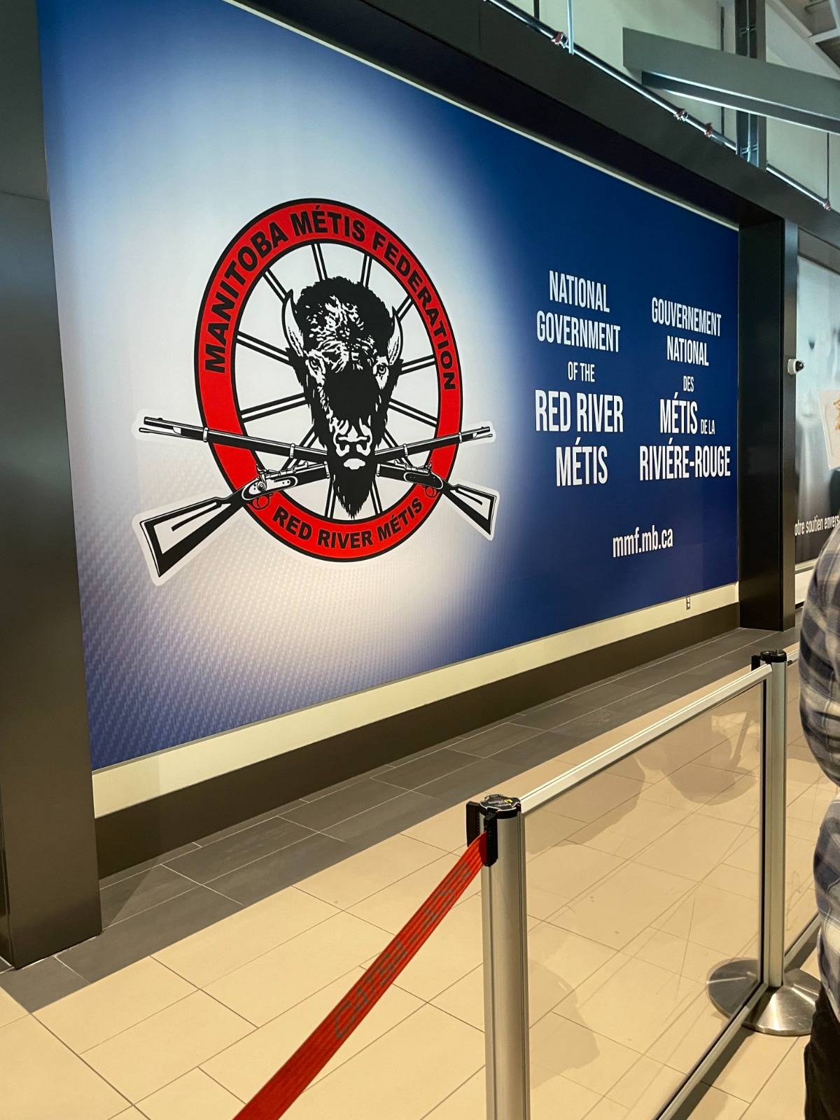 A poster with the Manitoba Metis Federation logo reads "National Government of the Red River Metis"