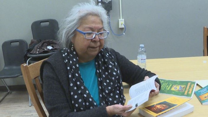 Pat Ningewance reads from one of her Ojibwe language books.