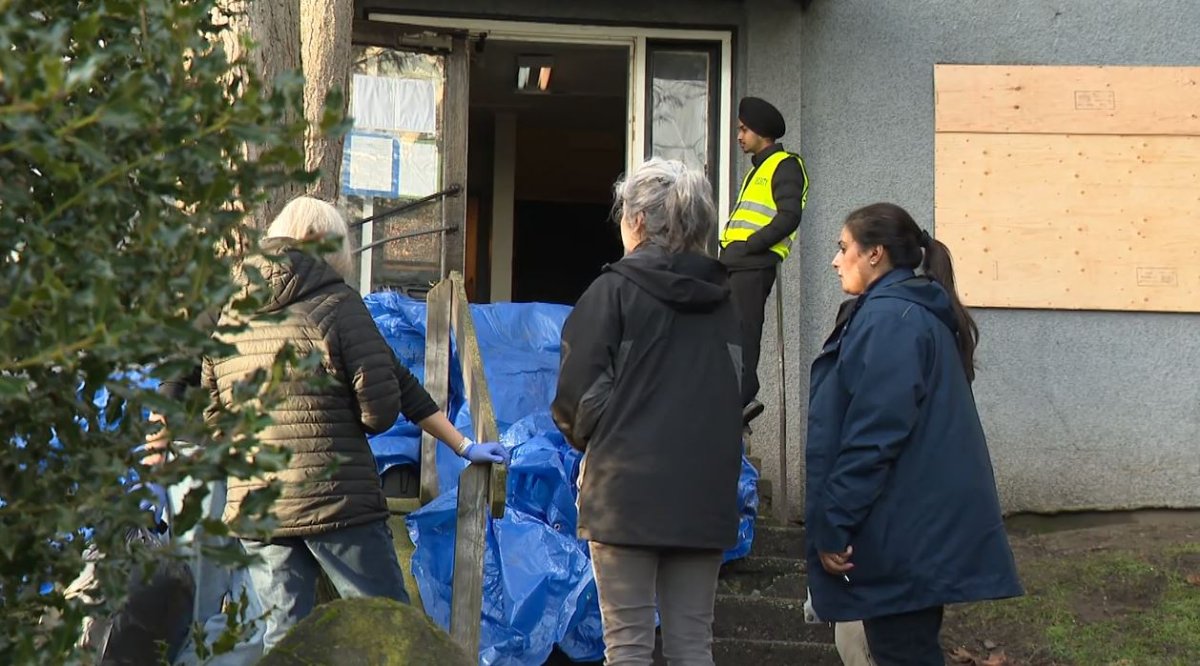 City staff supervise the evacuation or an unsafe apartment building in New Westminster on Friday. 