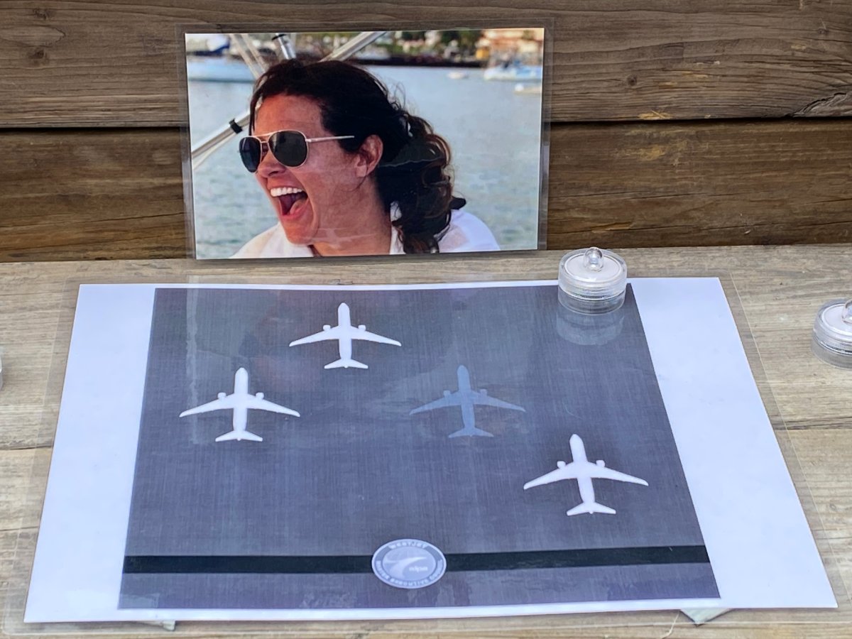 A photo of WestJet Capt. Christina Thomson, candles and a laminated WestJet image outside the home in southwest Calgary where Thomson and an unidentified man were found dead on Dec. 15.