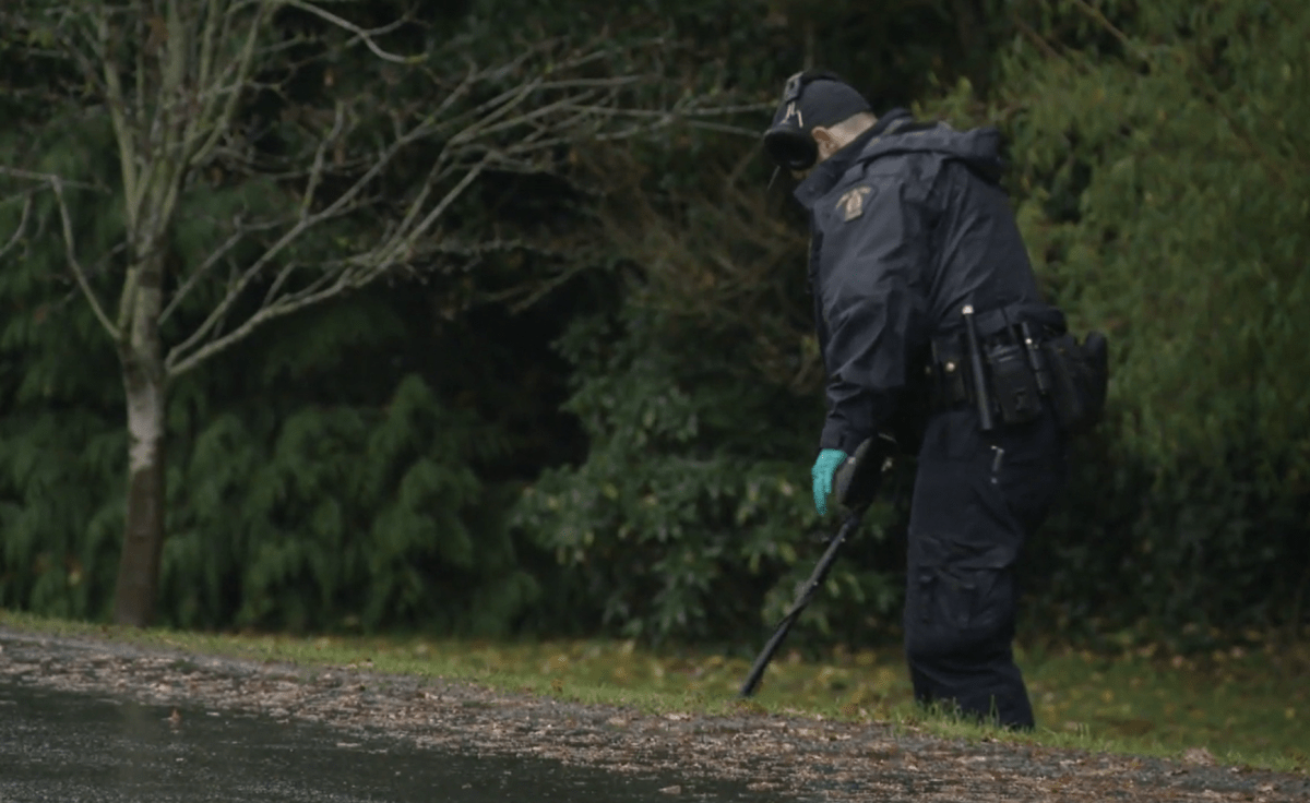 An RCMP investigator probes the scene of a shooting with a metal detector in White Rock, B.C. on Mon. Dec. 4, 2023.
