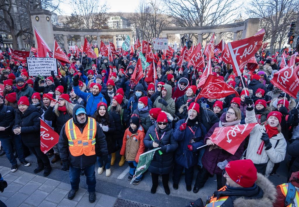 Striking teachers and their supporters hold a rally in front of Premier François Legault's office, Friday, Dec. 22, 2023, in Montreal. Around 420,000 Quebec public sector workers will see their wages rise by 17.4 per cent over the next five years. THE CANADIAN PRESS/Ryan Remiorz.