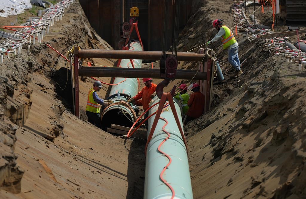 The Trans Mountain pipeline expansion is facing further delay, the company behind the project announced Monday. Workers lay pipe during construction of the Trans Mountain pipeline expansion on farmland, in Abbotsford, B.C., Wednesday, May 3, 2023. THE CANADIAN PRESS/Darryl Dyck