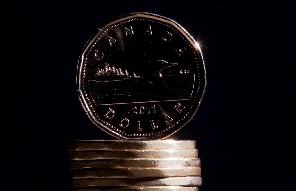 Canadian one dollar coins are stacked one on top of the other.