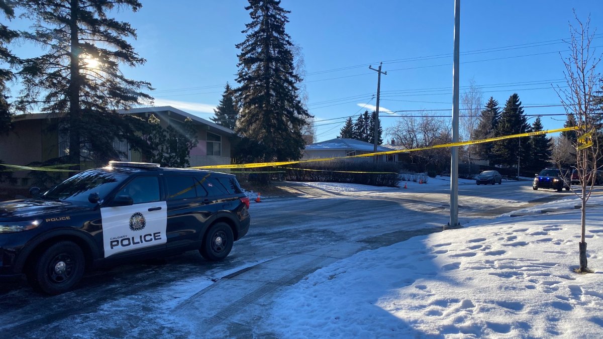 A CPS unit and crime scene tape outside of a home on Braden Crescent Northwest after officers found one man dead and two people injured during an investigation into a home invasion.