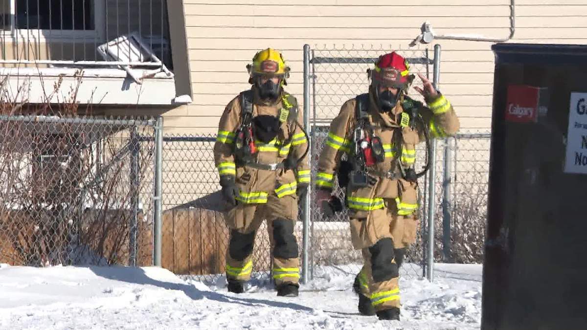 Calgary Fire Department crews wearing self-contained breathing apparatuses exit an apartment building during a carbon monoxide leak call, pictured on Jan. 12, 2024.