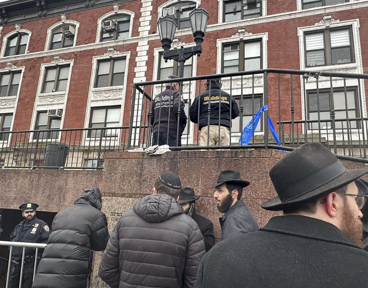 City inspectors and police officers outside the Brooklyn borough, N.Y., headquarters of the Chabad movement, Tuesday, Jan. 9, 2024.