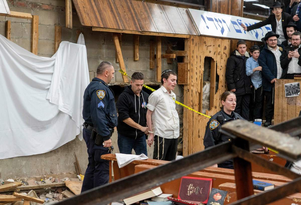 New York Police officers arrest a Hasidic Jewish student after he was removed from a breach in the wall of the synagogue that led to a tunnel dug by students, Monday, Jan. 8, 2024, in New York.