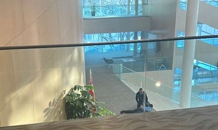 A person appears to be detained by another person at Edmonton City Hall on Jan. 23, 2024 as police investigated a weapons complaint.