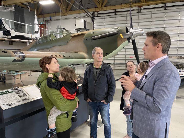 The Hangar Flight Museum's Brian Desjardins tells visitors about the exhibit featuring aviation pioneer Elsie MacGill.