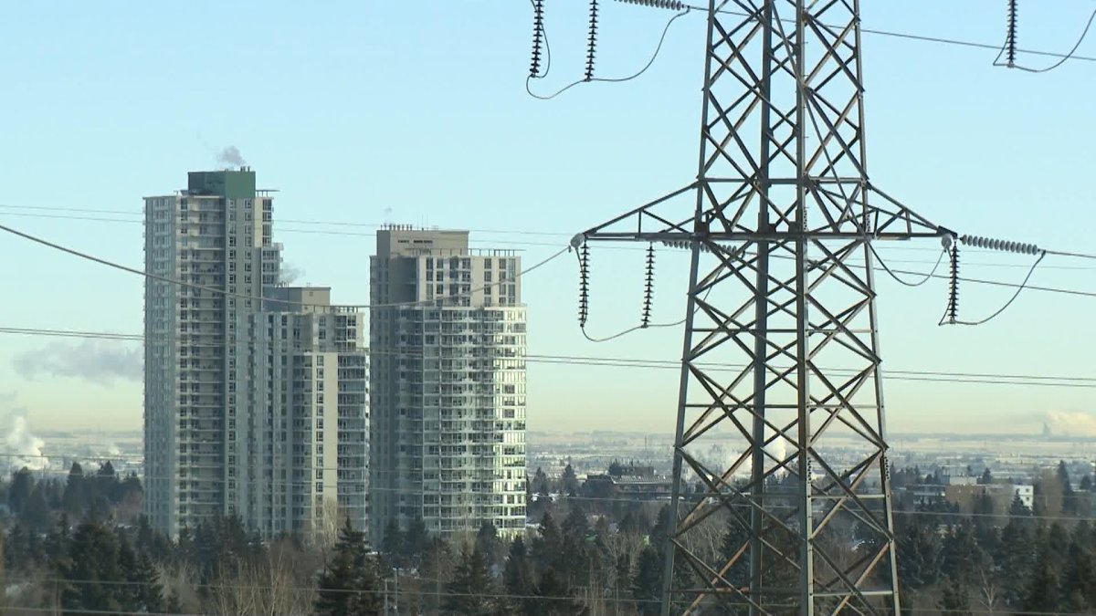 File photo of power transmission lines carrying electricity to Calgary-area homes are seen in the foreground, with apartments in the background.