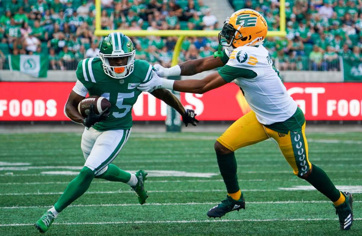 Saskatchewan Roughriders receiver Shawn Bane Jr. (15) runs the football as Edmonton Elks defensive back Loucheiz Purifoy (0) defends during the first half of CFL football action in Regina, on Thursday, July 6, 2023. Purifoy will return for a second season with the Edmonton Elks.
