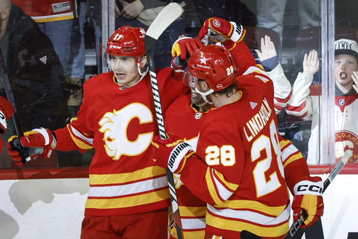 Calgary Flames forward Yegor Sharangovich (17) celebrates his overtime goal with teammates during NHL hockey action against the Arizona Coyotes in Calgary, Tuesday, Jan. 16, 2024.