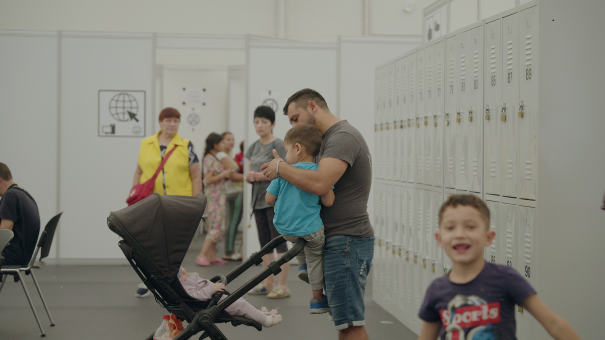 Volodymyr and his children navigate the camp as they await housing from the state.