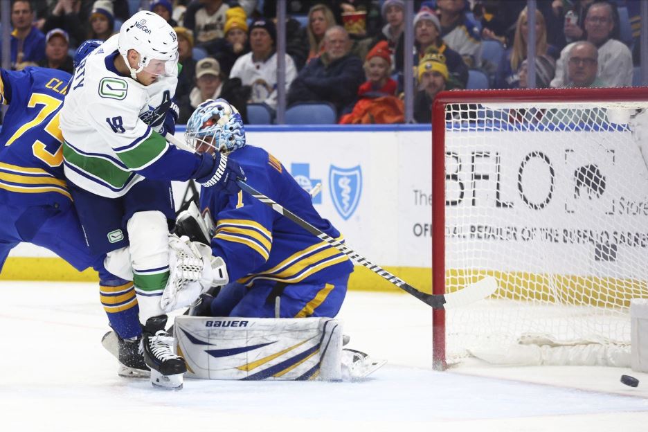 Vancouver Canucks center Sam Lafferty (18) puts the puck past Buffalo Sabres goaltender Ukko-Pekka Luukkonen (1) during the second period of an NHL hockey game Saturday, Jan. 13, 2024, in Buffalo, N.Y.