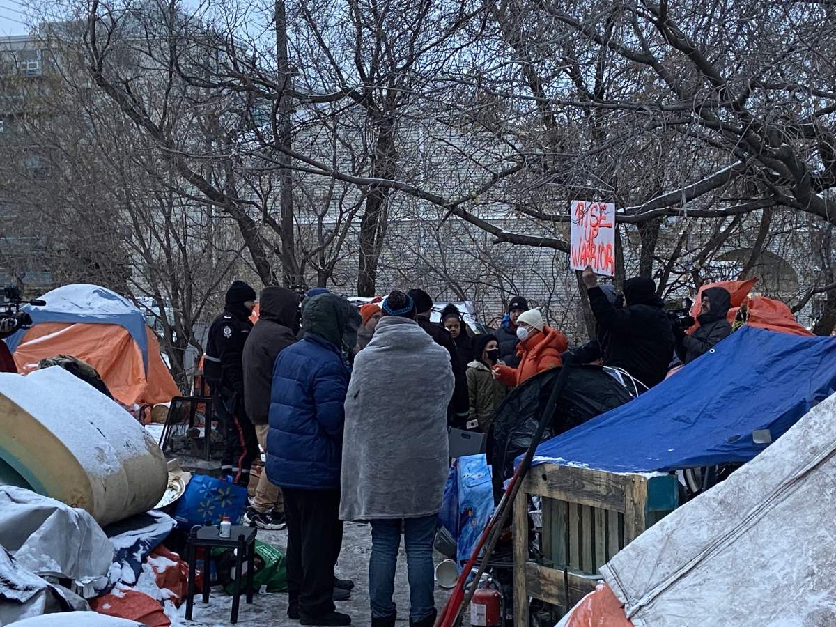 Edmonton police and representatives with the City of Edmonton prepare to dismantle a homeless encampment in the area of 95 Street and Rowland Road Tuesday, Jan. 9, 2024.