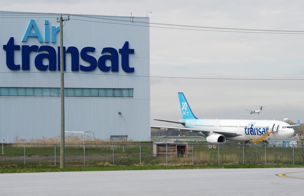 An Air Transat plane is seen as an Air Canada plane lands at Pierre Elliott Trudeau International Airport in Montreal.