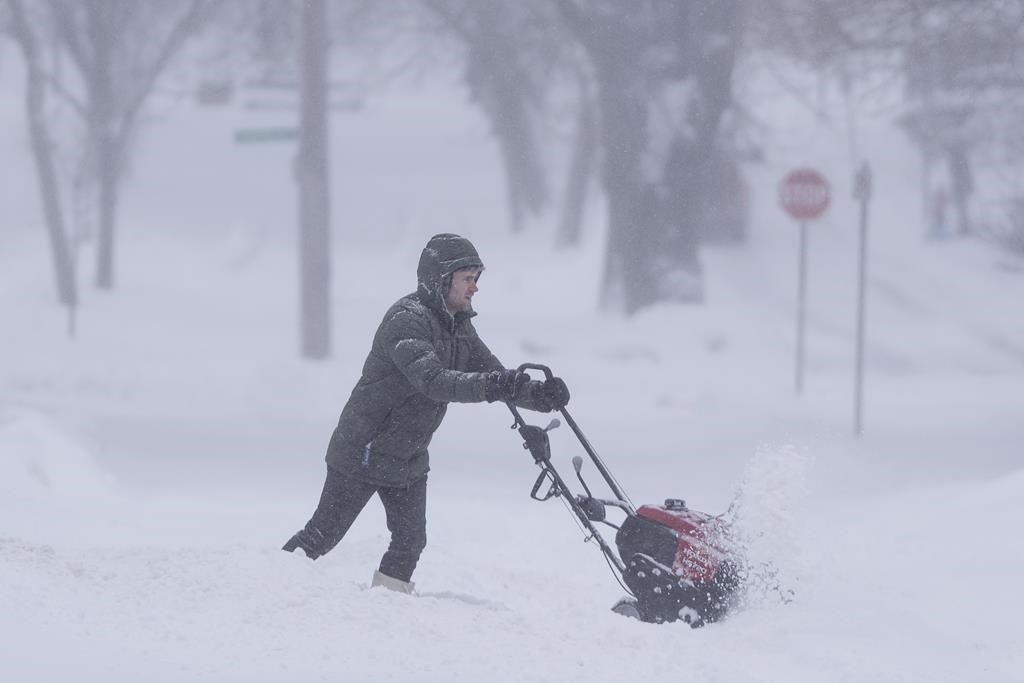 A person uses a snowblower to clear snow in Halifax on Saturday.