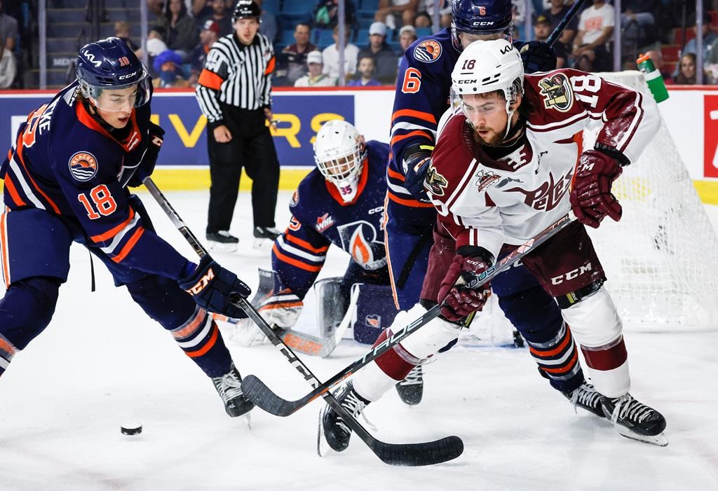 Peterborough Petes forward Connor Lockhart, right, chases the puck with Kamloops Blazers defenceman Harrison Brunicke, left, as goalie Dylan Ernst, centre, looks on during first period Memorial Cup hockey action in Kamloops, B.C., Thursday, June 1, 2023. Lockhart, now with the Oshawa Generals, has been suspended indefinitely by the team and the Ontario Hockey League after it was learned he is under investigation by Durham Regional Police. 