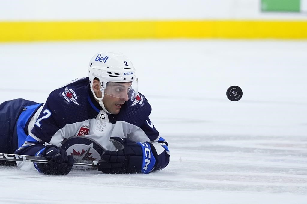 Winnipeg Jets’ Dylan DeMelo dives after the puck during a game against the Philadelphia Flyers on Feb. 8, 2024, in Philadelphia.