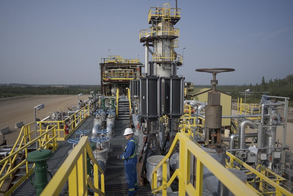 A worker stands on a steam-assisted gravity drainage pad at Cenovus' Sunrise oil facility northeast of Fort McMurray on Thursday, Aug. 31, 2023. Cenovus Energy Inc. reported a fourth-quarter of $743 million, down from $784 million a year earlier, as its revenue also edged lower. THE CANADIAN PRESS/AP/Victor R. Caivano
